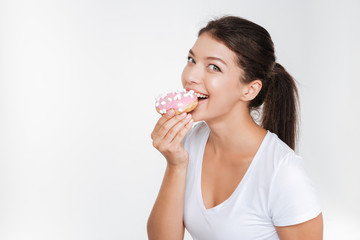 Cute young woman eating tasty donut