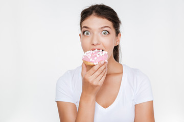Confused diet young woman eating tasty donut