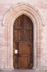Entrance door of St. Claire Cathedral in Assisi, Italy