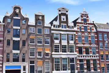 Old town houses of cobblestone with clear blue sky. Antique, traditional row houses in Amsterdam, the Netherlands.