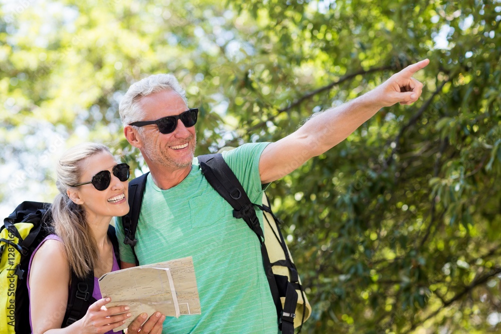 Poster Couple pointing and holding a map 