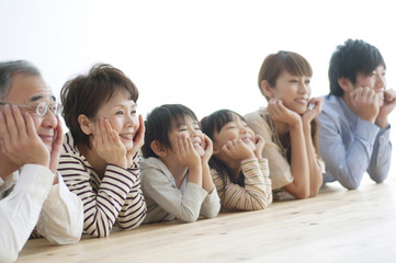 床に寝転ぶ3世代家族