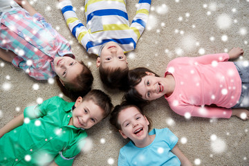 happy smiling children lying on floor over snow
