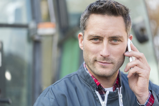 Farmer Leaning On The Tractor Using A Phone