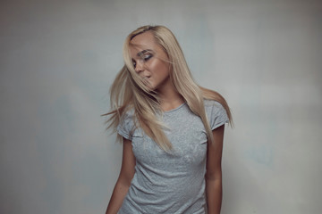 Pretty blonde woman posing in light room