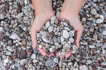 Hands holding pile of stones