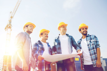 group of builders with tablet pc and blueprint