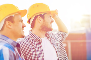 group of smiling builders in hardhats outdoors