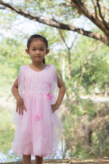 Little asian girl with tree near lagoon