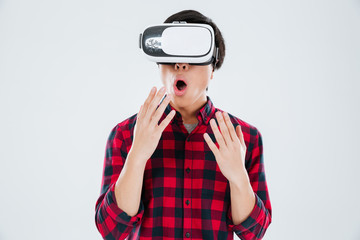 Surprised asian man wearing virtual reality device