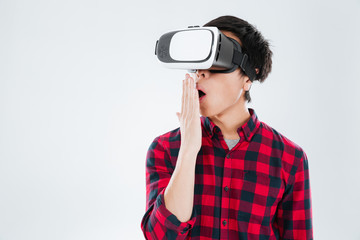 Obraz premium Surprised asian man dressed wearing virtual reality device
