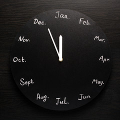 Black round clock calendar. 12 months