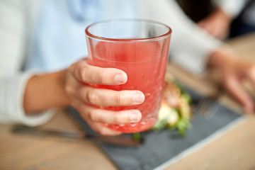 hand with glass of juice at restaurant