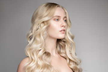 Portrait Of A Beautiful Young Blond Woman With Long Wavy Hair.