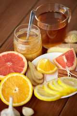 ginger tea with honey, citrus and garlic on wood