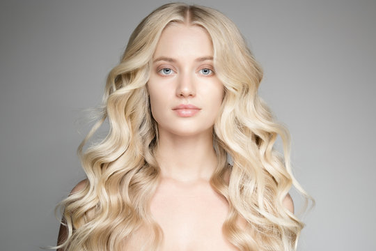 Portrait Of A Beautiful Young Blond Woman With Long Wavy Hair.
