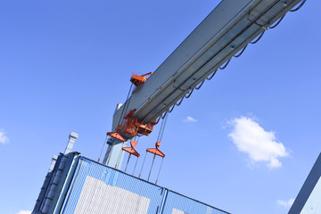 Container harbor, detail shot of a crane lifting up a cargo container.