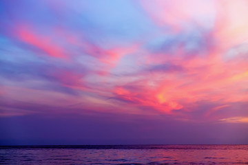 Fototapeta premium Tropikalny kolorowy dramatyczny zmierzch z chmurnym niebem i sylwetką statek na horyzoncie. Wieczorny spokój nad Zatoką Tajlandzką. Jasna poświata.