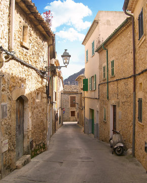 Fototapeta Narrow street in a spanish village with antique streetlight.