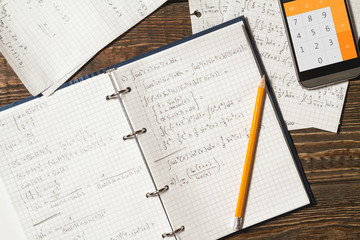 Mathematical equations written in a notebook. Calculator app.