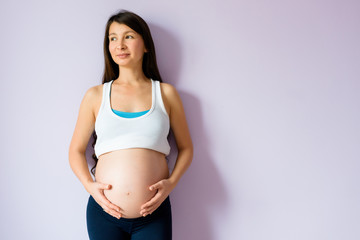 Pregnant asian woman holding a belly