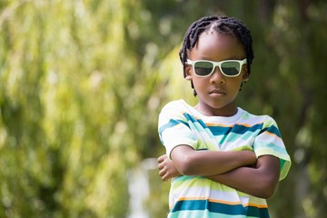 Naklejka premium A kid with sunglasses crossing his arms