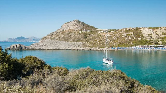 Ladiko Beach in Rhodes Greece with Blue Mediterranean Sea Water with Umbrellas in the Bay on a Sunny Day