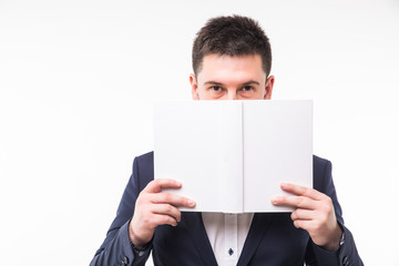 Young man in suit cover face with book over white background