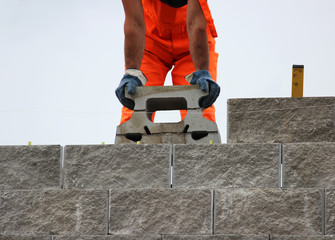 Bricklayer putting down another row of bricks in site during the construction  the viaduct.
