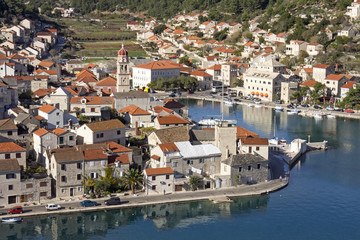 Fototapeta na wymiar Red roofs and white stone houses in deep bay in village Pucisca on island Brac in Croatia