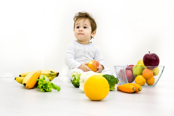 Fototapeta premium baby surrounded with fruits and vegetables, healthy child nutrition