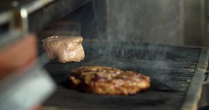 Chef prepares beef steak 4k refocus video: flips meat in grill charcoal oven. Cooking  process on barbecue restaurant kitchen