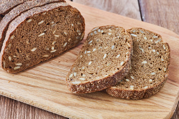 Slice of rye bread with seeds on a wooden background сlose up.