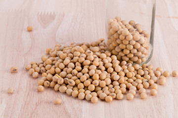 Close up Soybean in a glass bottle on wooden table.