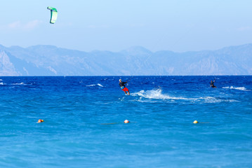 Kitesurfer in action on clear blue tropical water, Rhodes Island, Greece