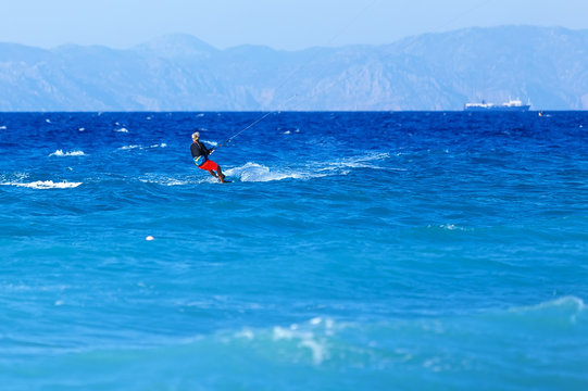 man has kite. Most popular places in Rhodes Greece for kitesurfing.