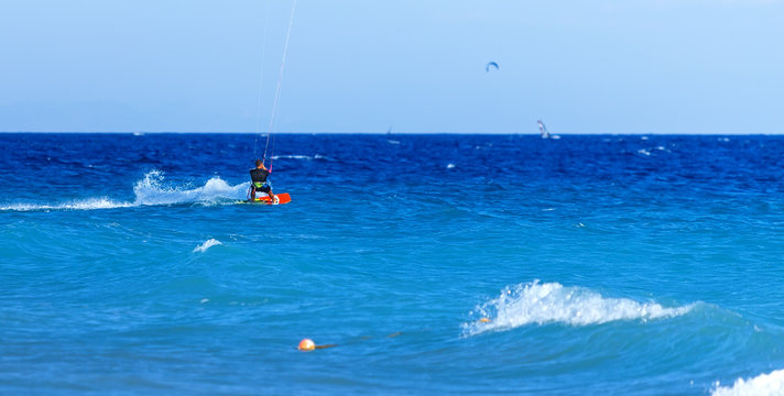 kite surfer rides on the waves of Aegean Rhodes Greece.  bright Sunny day