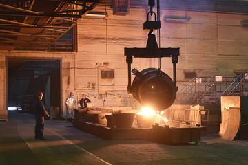 Arbeiter in einer Giesserei - giessen von Gusstücken in einer Fabrik