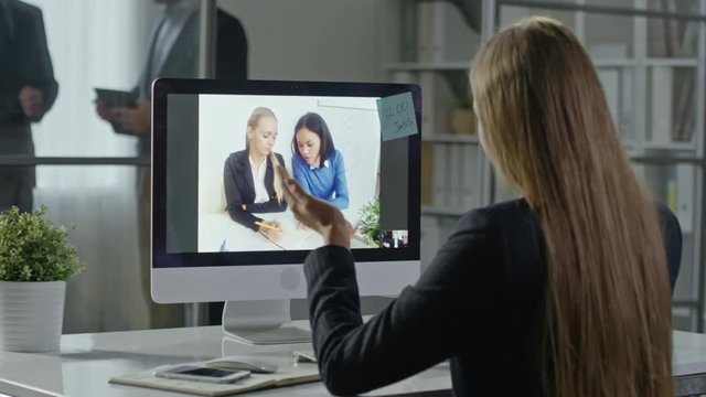 Businesswomen having video conference with two female colleagues in the office 