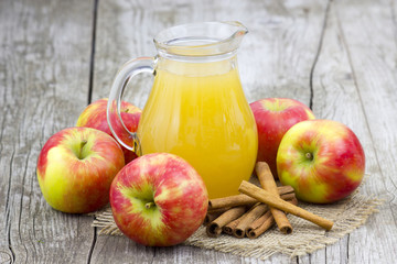 Apple juice and apples on wooden background