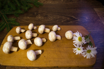 Fototapeta na wymiar champignon mushrooms on a wooden board