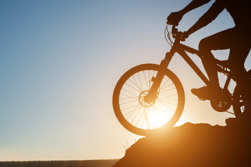 Fototapeta na wymiar Silhouette of a man on mountain-bike during sunset.