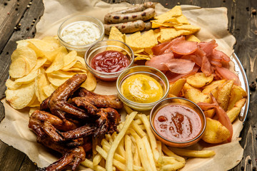 wide selection of snacks for beer with different sauces on parchment top view