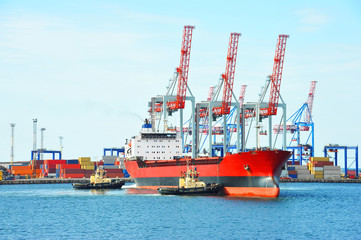 Fototapeta premium Tugboat assisting bulk cargo ship