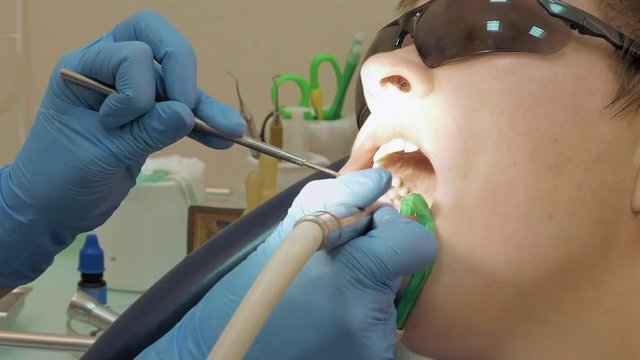 Woman at the dentist clinic office gets dental medical examination and treatment. Odontic and mouth health is important part of modern human life that dentistry help with.