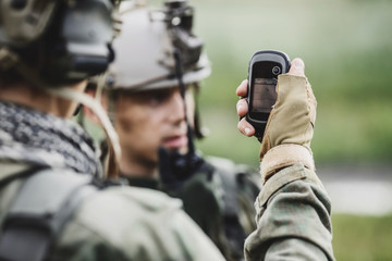 soldiers holding navigator in hand and determines the location operation