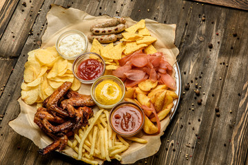 wide selection of snacks for beer with different sauces on parchment top view