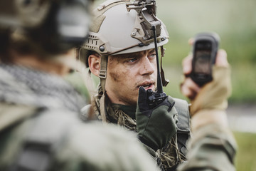 soldiers holding navigator in hand and determines the location operation