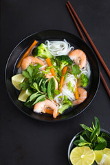 asian rice noodle, shrimps and vegetable soup in bowl