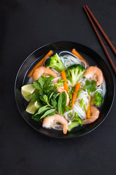 asian rice noodle, shrimps and vegetable soup in bowl